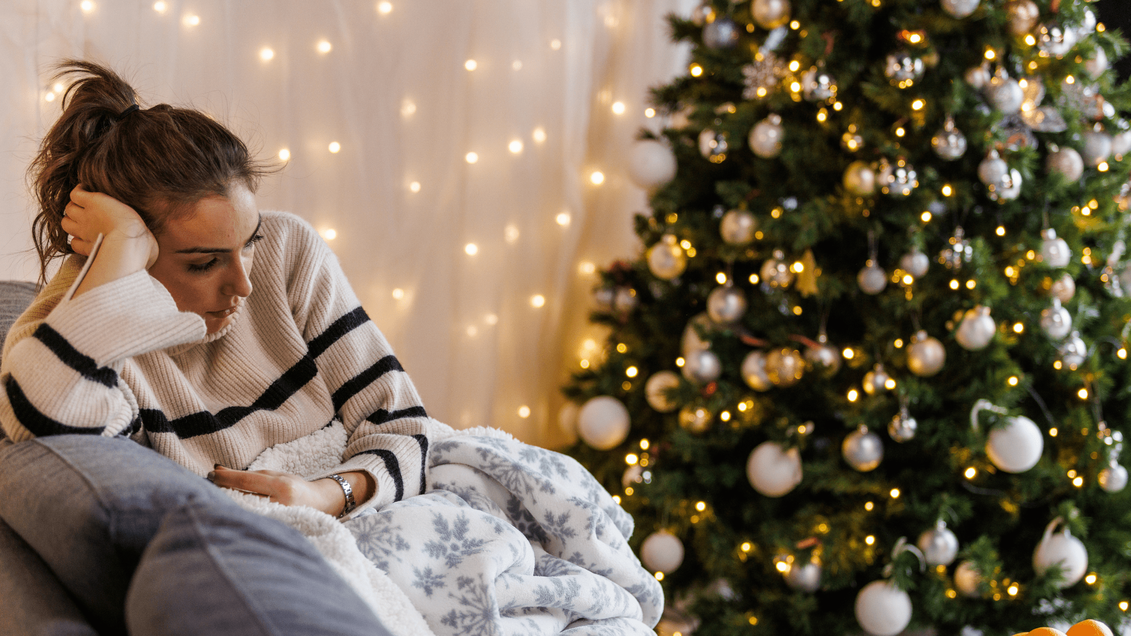 Woman sad at Christmas in front of Christmas tree