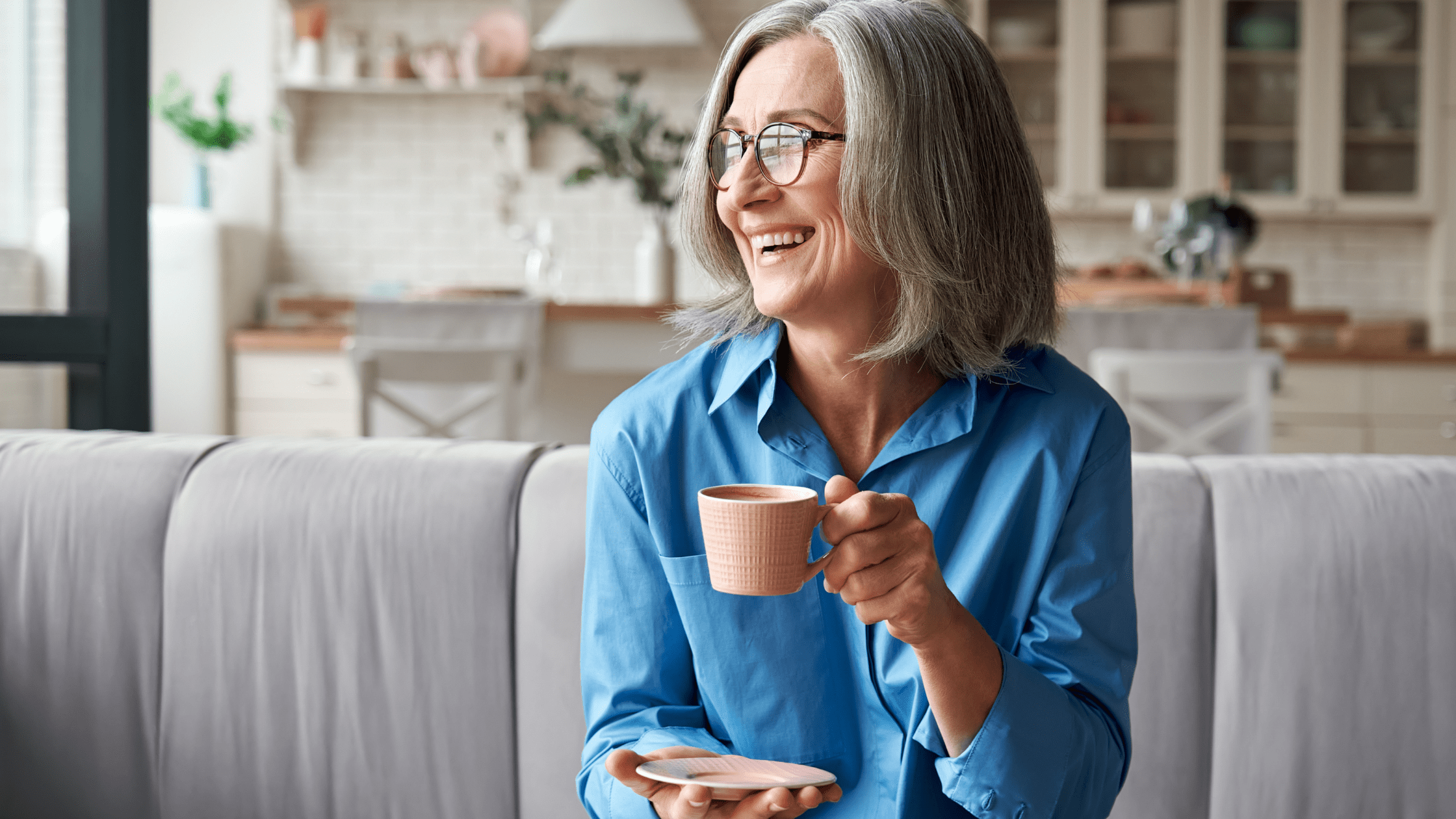 Woman sitting on her sofa drinking coffee