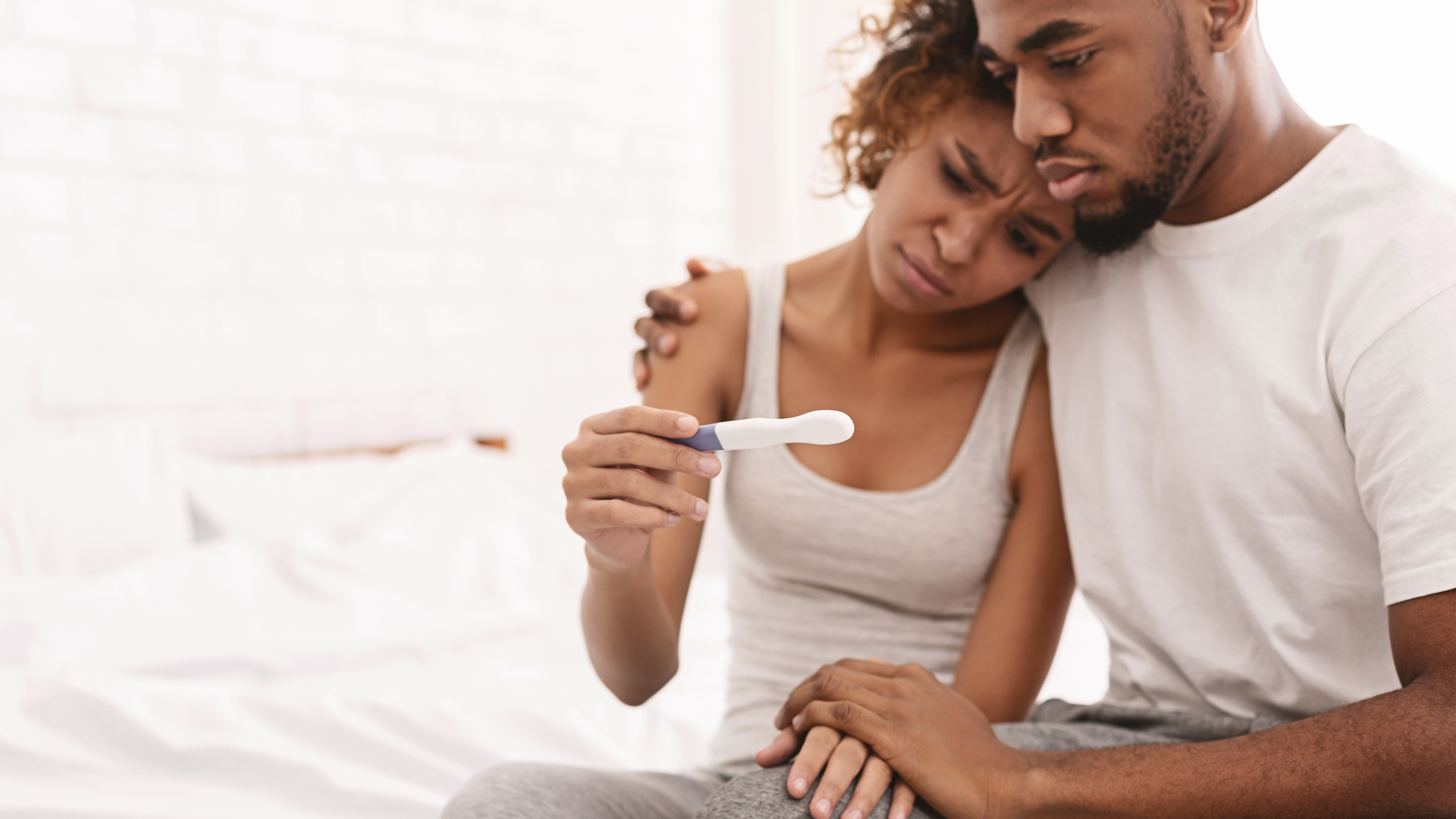Male and female couple looking at negative pregnancy test