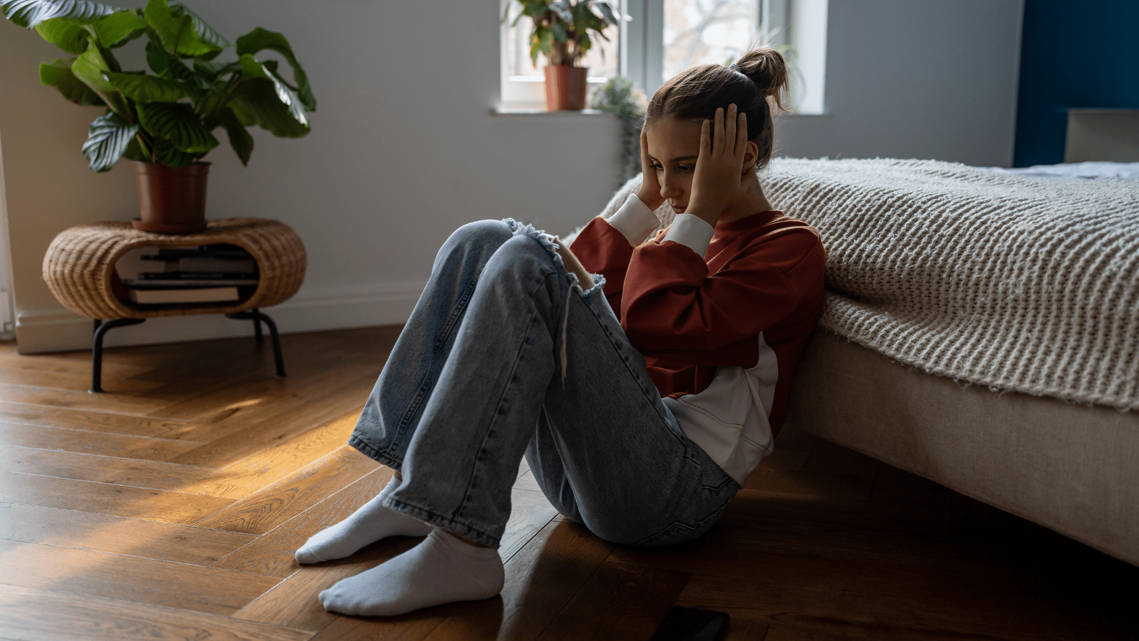 Young female distraught in her bedroom