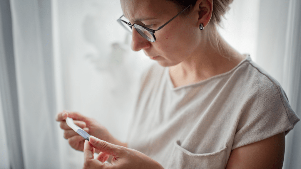 Woman in her 40s looking at a pregnancy test to see if she is pregnant