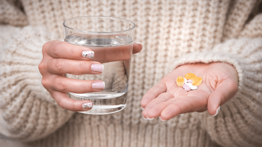 woman with a glass of water and supplements 